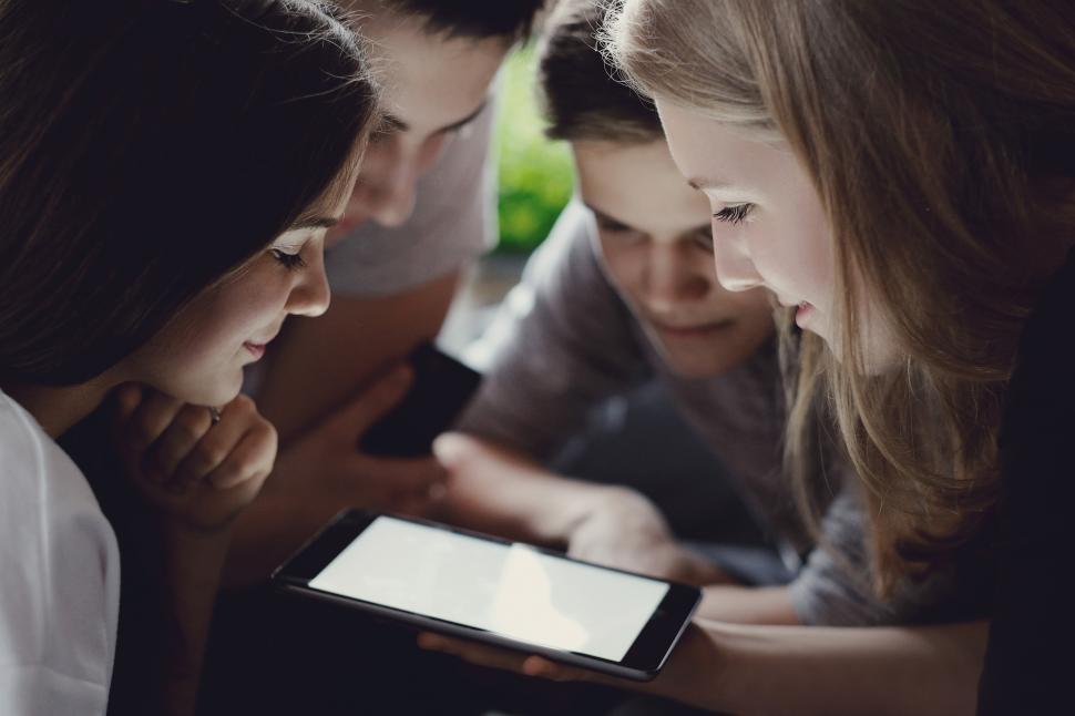 Free Image of Teenagers around a blank phone - insert content 