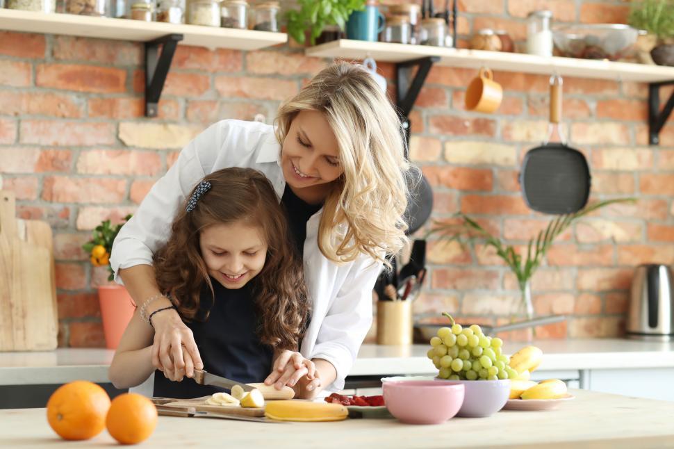 Free Image of Mother and daughter slice fruit in the kitchen 