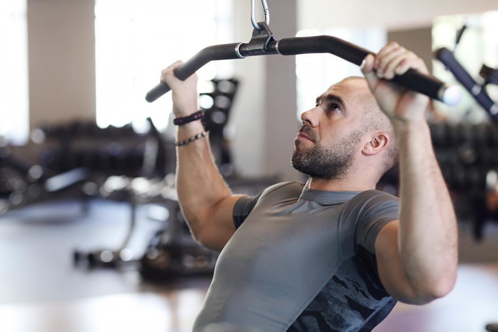 Free Image of Man in the gym doing pull-downs 