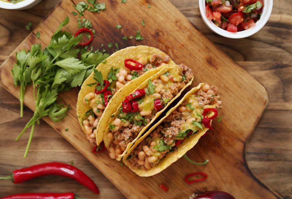 Free Image of Three fresh tacos on a board 