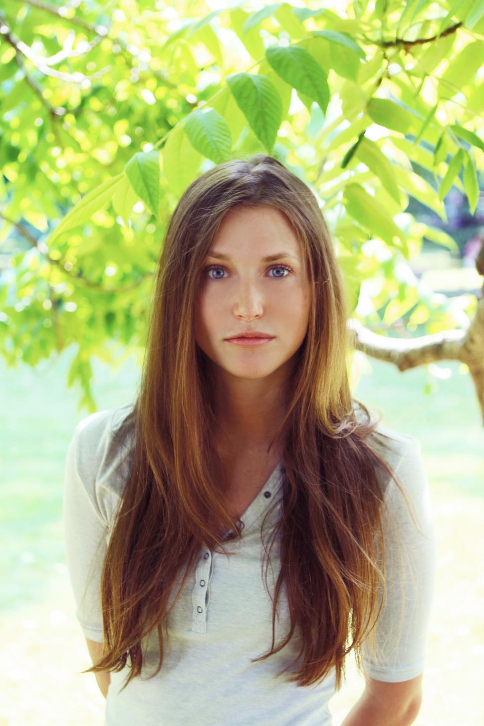 Free Image of Young woman in tree leaves 