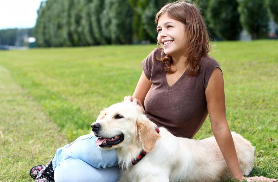 Free Image of Young woman with her dog sitting in a park 