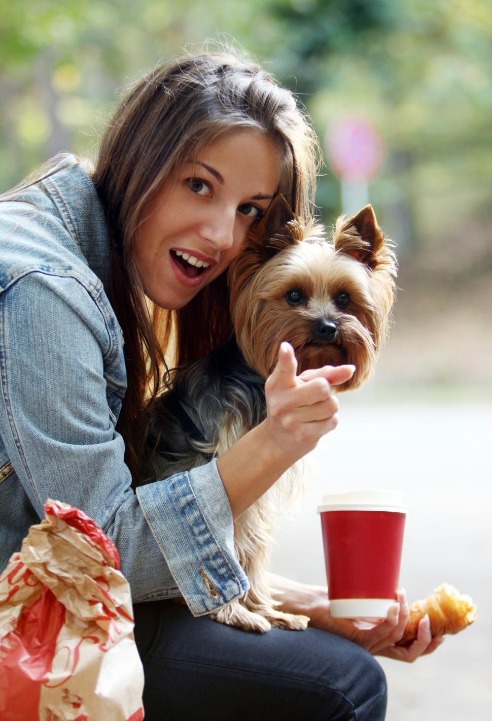 Free Image of Woman eating lunch with her dog 