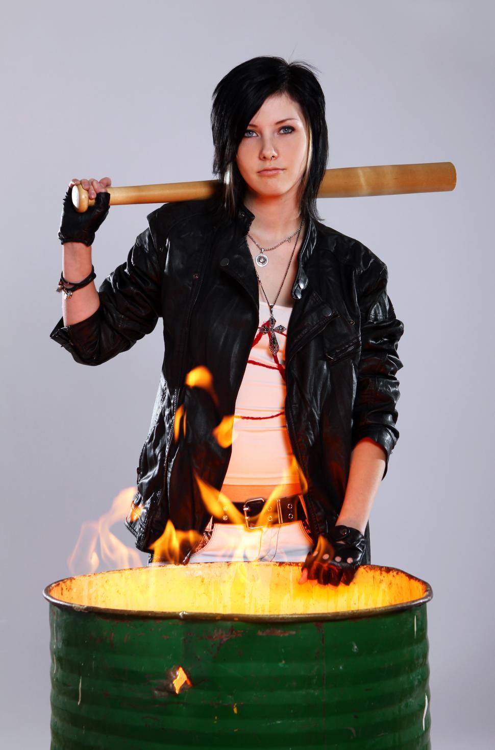 Free Image of Woman with bat by burning barrel  