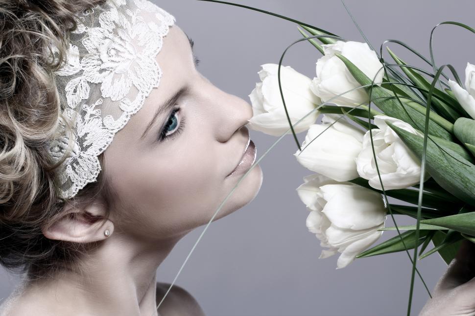 Free Image of Woman sniffing white tulips 