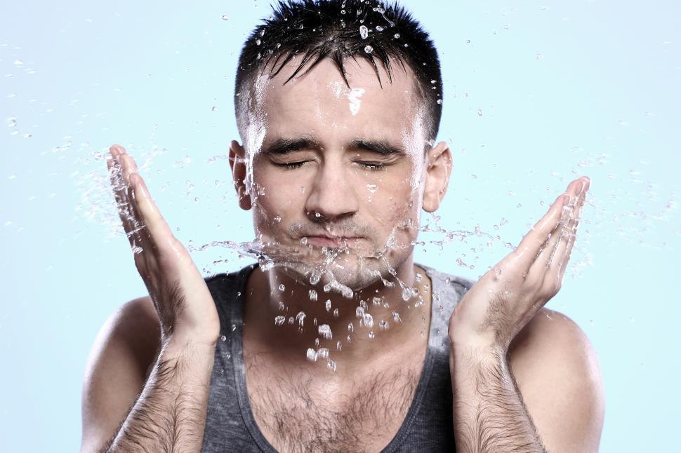 Free Image of Guy washing his face after a shave 