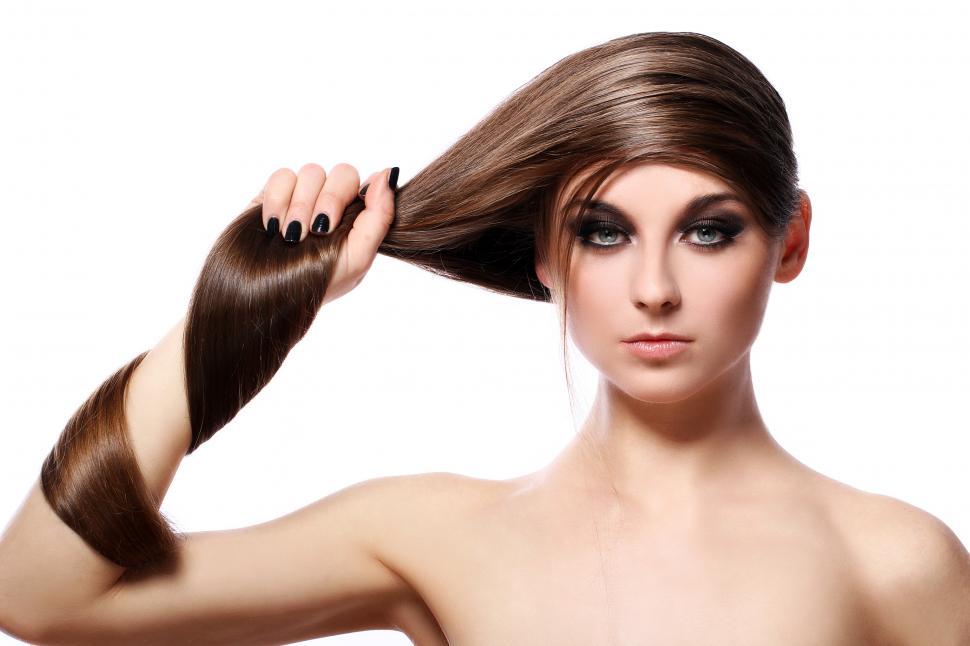Free Image of Young woman with long hair wrapping her arm 