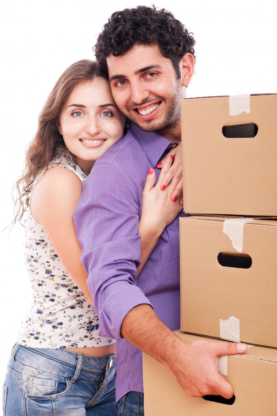 Download Free Stock Photo of Young couple carrying moving boxes 