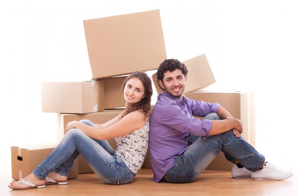 Free Image of Young and happy couple posing with moving boxes 