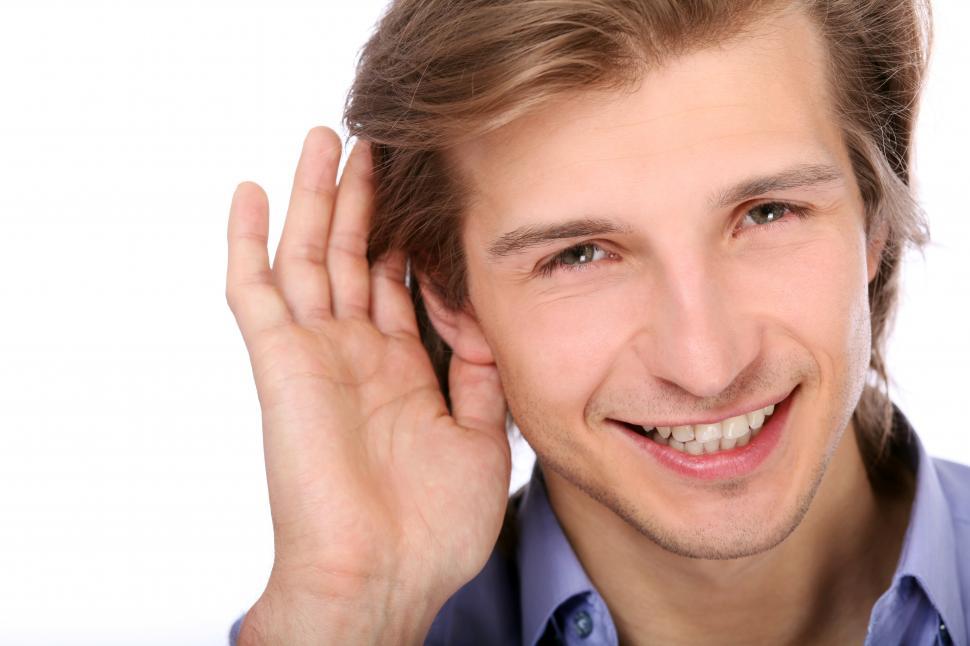 Free Image of Young man listening with hand on ear 