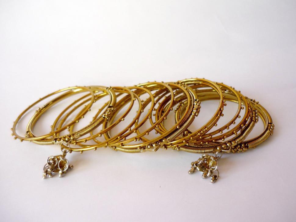 Free Image of Collection of Gold Colored Bracelets on White Background 