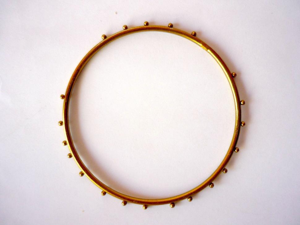Free Image of Close Up of a Gold Bracelet on a White Surface 