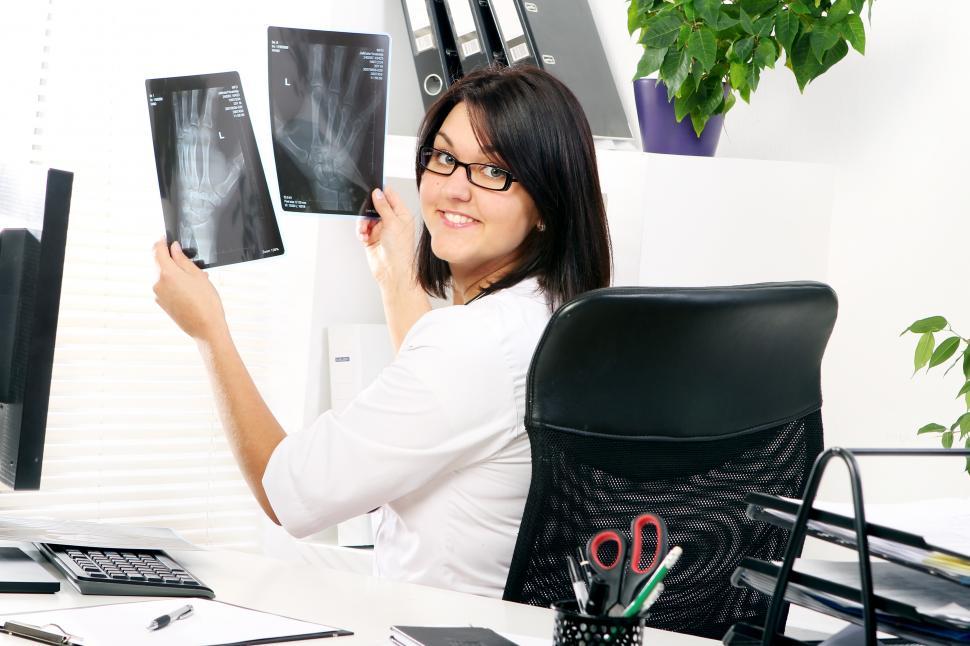 Free Image of Young woman doctor is looking at xray 