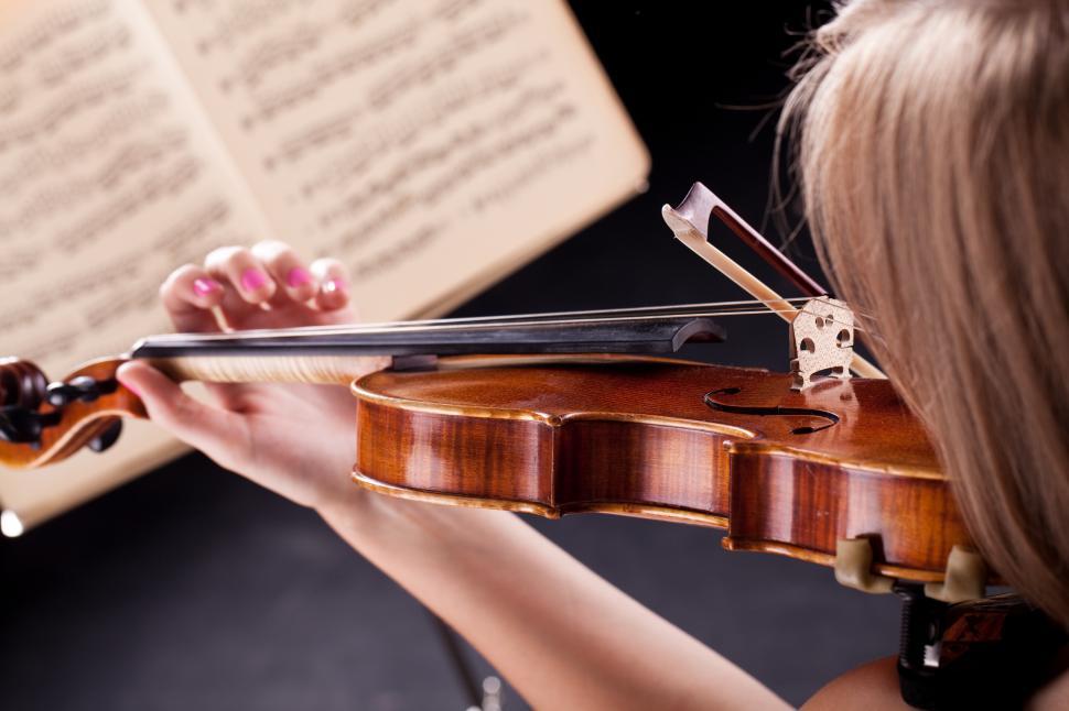 Free Image of Violin player playing from sheet music 