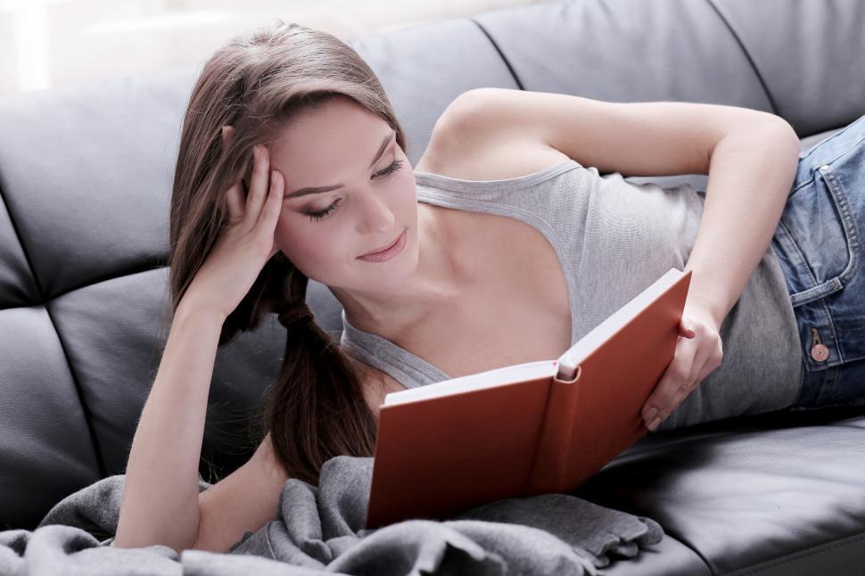 Free Image of Woman on the couch reading a book 