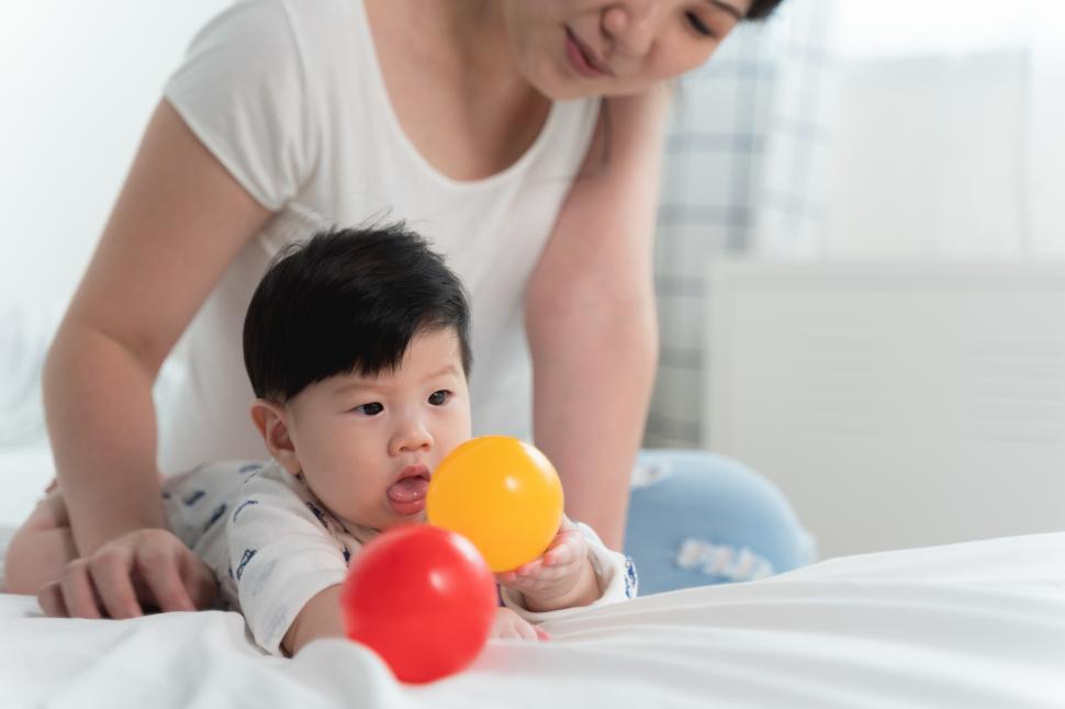 Free Image of Asian mother with asian baby on bed 