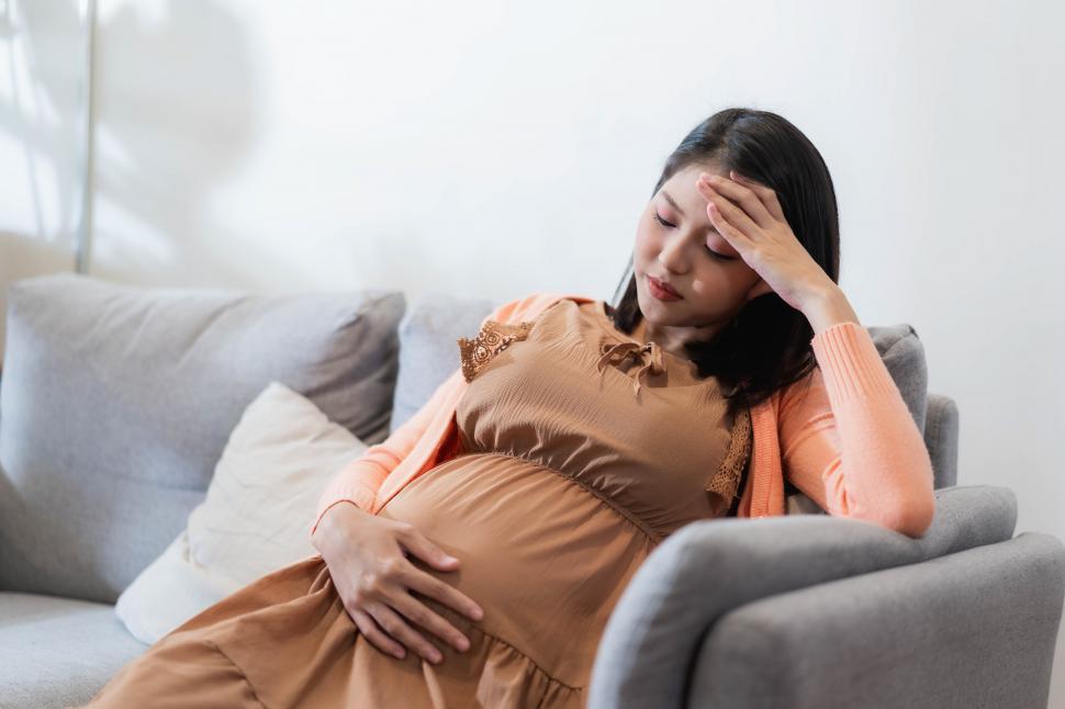 Download Free Stock Photo of Young pregnant asian woman has a headache 