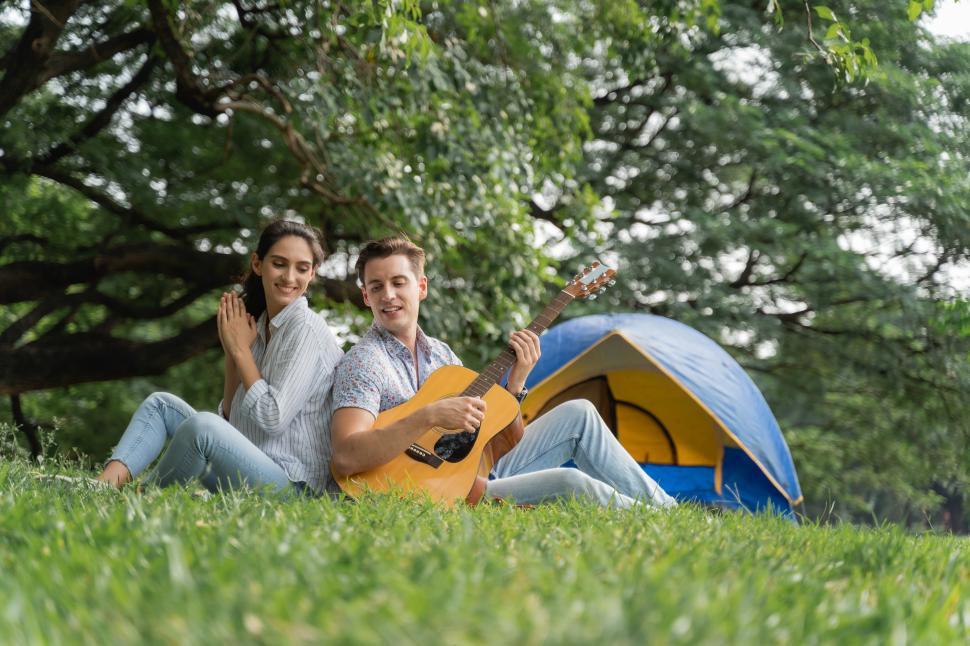 Free Image of Picnic and Camping time. Young couple having fun with guitar 