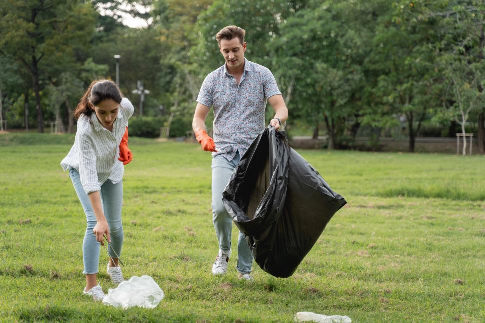 Free Image of Volunteer couple picking up trash and litter 