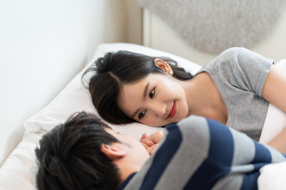 Download Free Stock Photo of young asian couple on bed in bedroom 