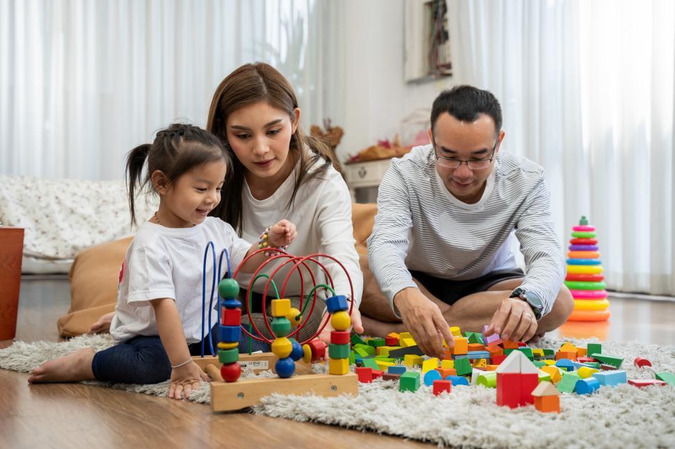 Free Image of Young father and mother and a daughter playing 