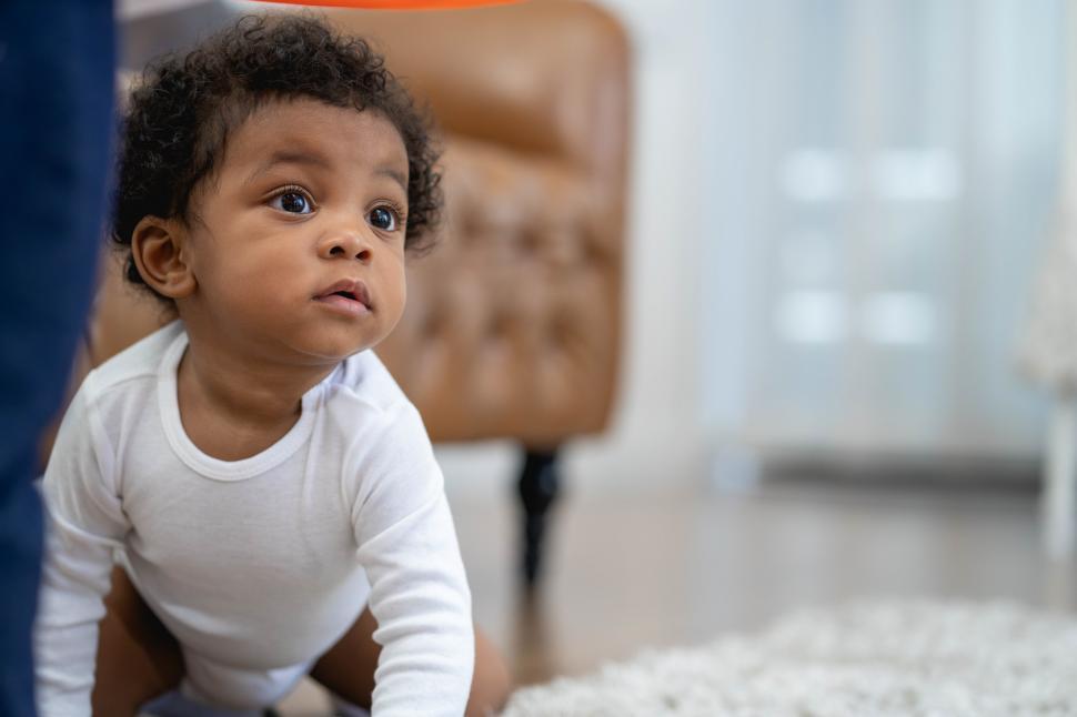 Free Image of African American baby boy crawling and looking around 