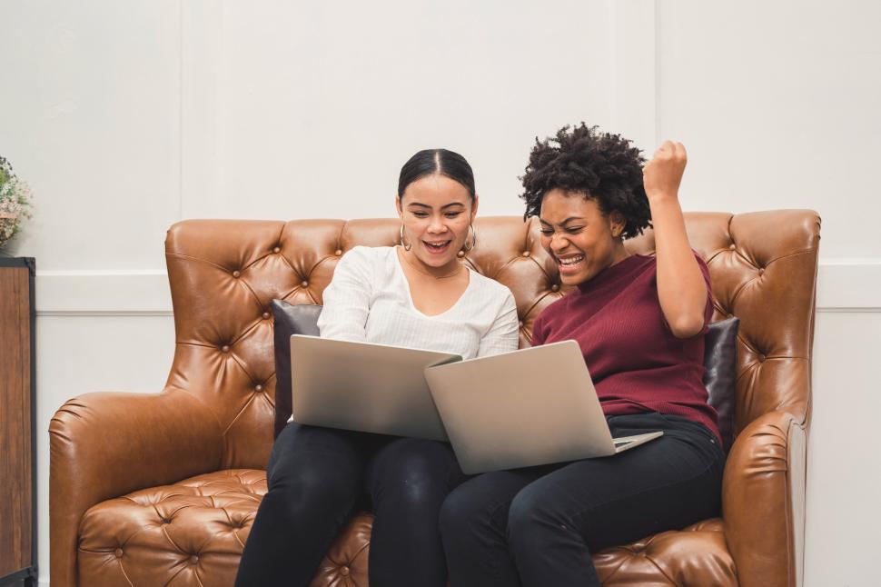 Free Image of Multicultural women using a laptop on couch 