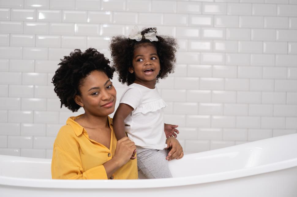 Free Image of Mother and baby daughter having fun and playing together at the bathroom 