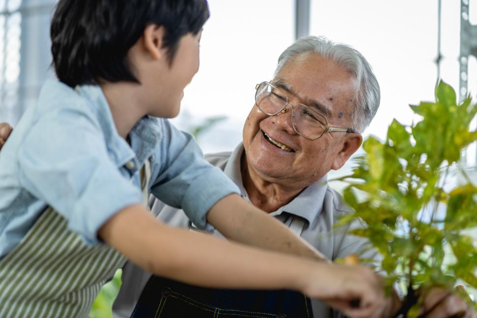 Free Image of Grandfather happily showing grandson how to garden 