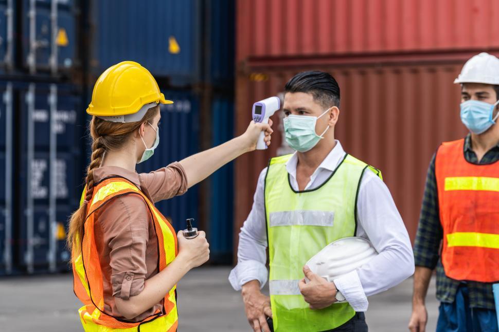 Download Free Stock Photo of Dock worker getting temperature check 