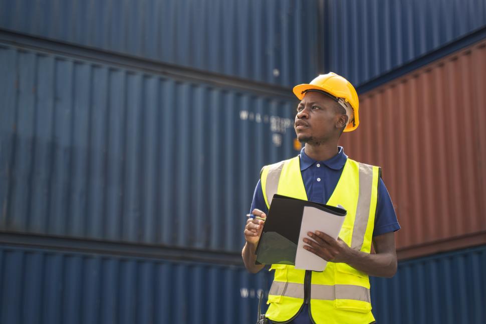 Free Image of Workman holding document, checking the containers 