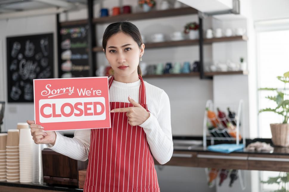 Free Image of Portrait of woman holding CLOSED sign 