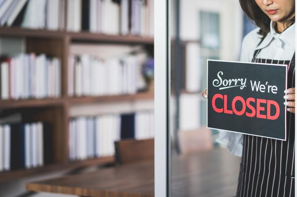 Free Image of Woman in shop with Sorry Were CLOSED sign 