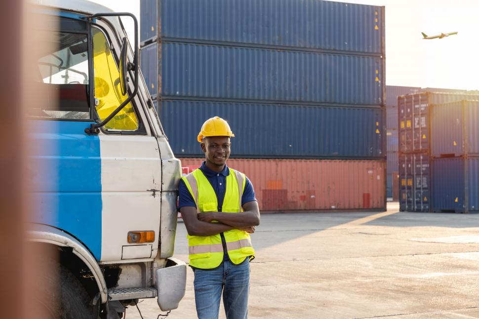 Free Image of Truck driver stands resting and smiling happily  