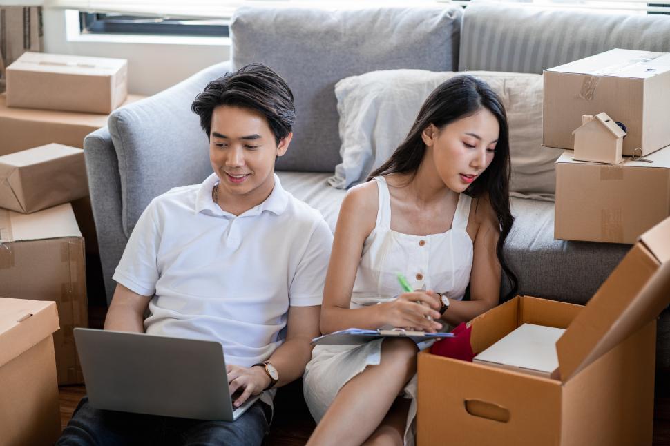 Free Image of Couple moving to new home, sitting on the floor 