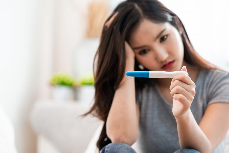 Free Image of Woman looking at pregnancy test results 