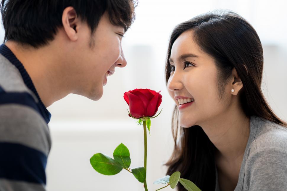 Free Image of A young man giving red rose to a young woman 