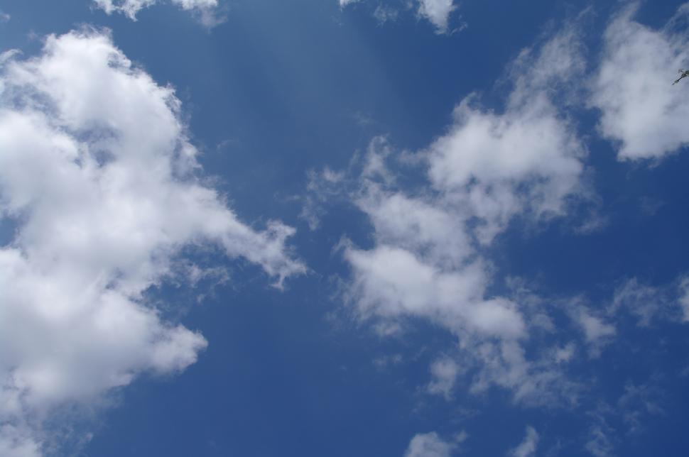 Free Image of Plane Flying Through Cloudy Blue Sky 