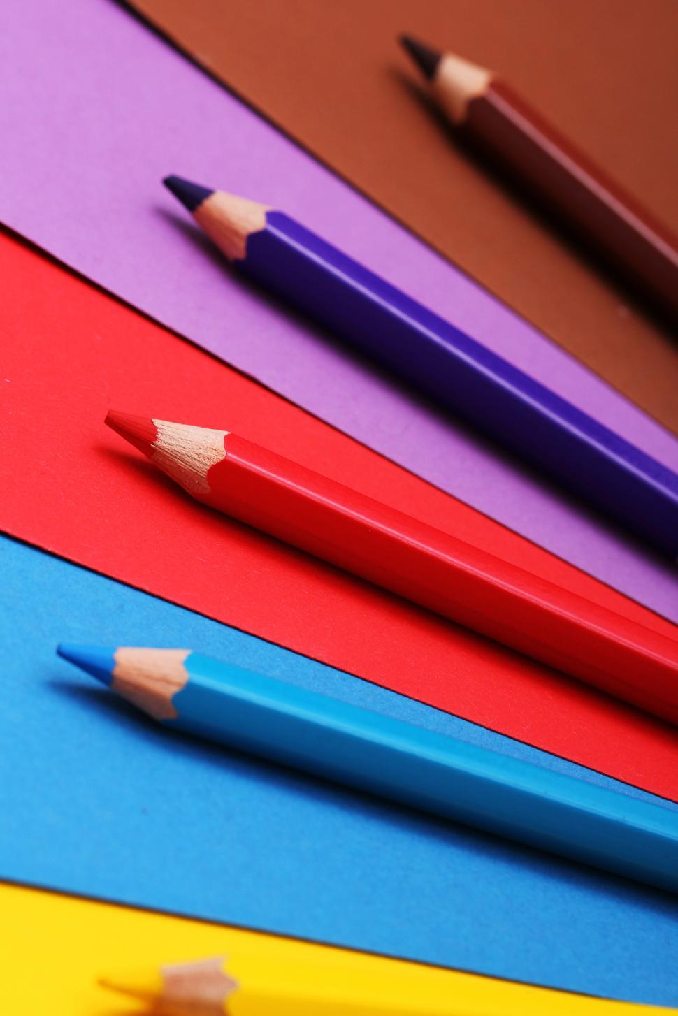 Free Image of Art pencils on colorful construction paper 