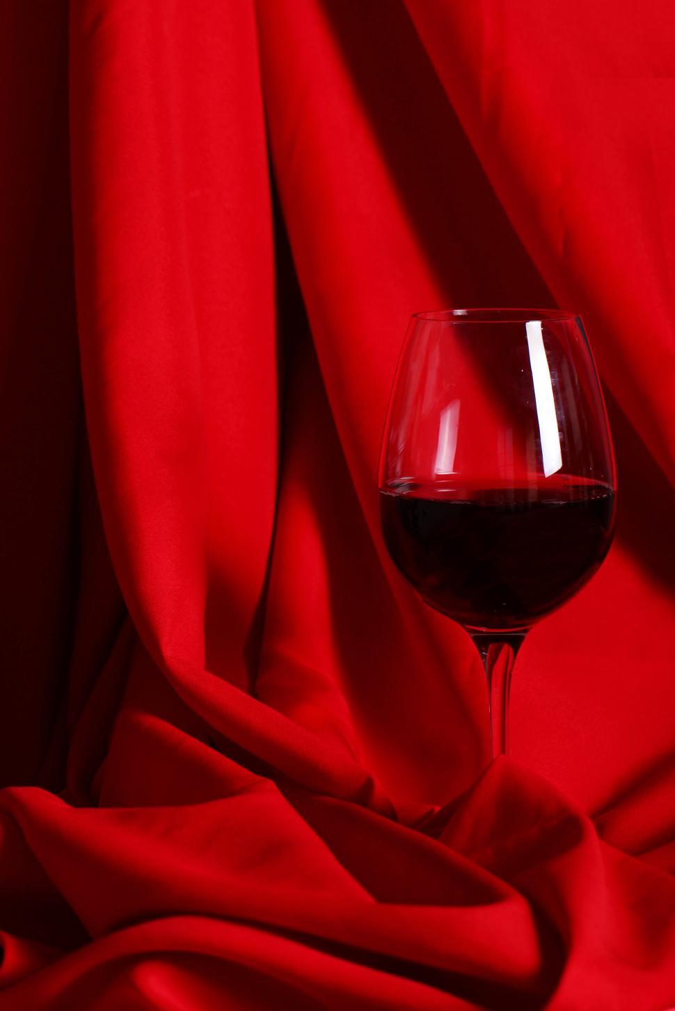 Free Image of Glass of red wine on red cloth 