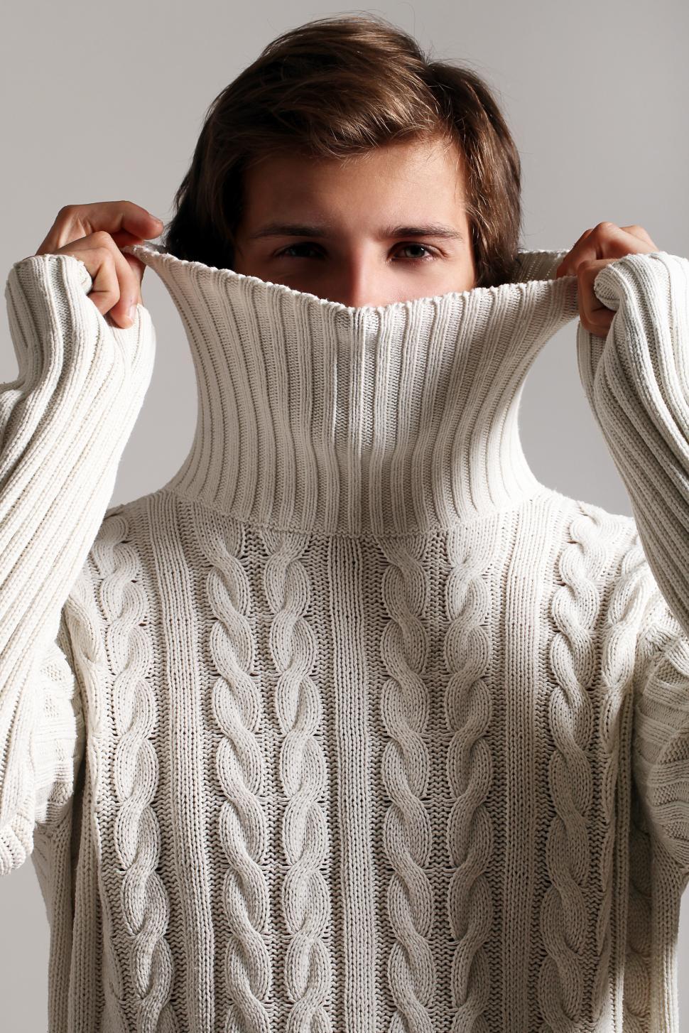 Free Image of Man peeks out from large white sweater 