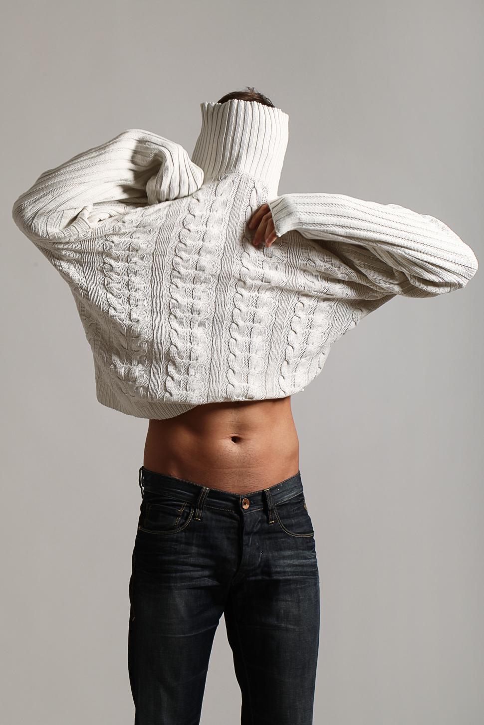 Free Image of Man is covered by giant sweater 