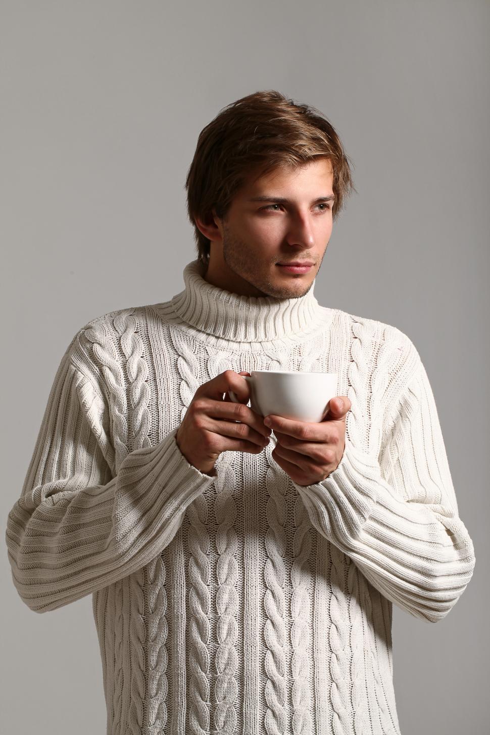 Free Image of Man with hot drink and big sweater 