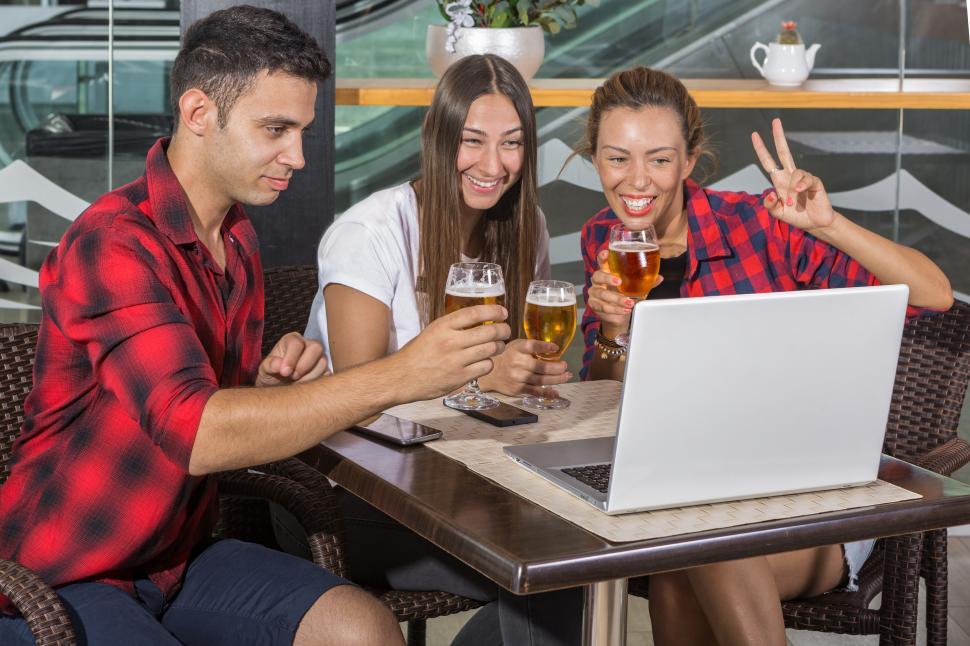 Free Image of Friends in pub with laptop 