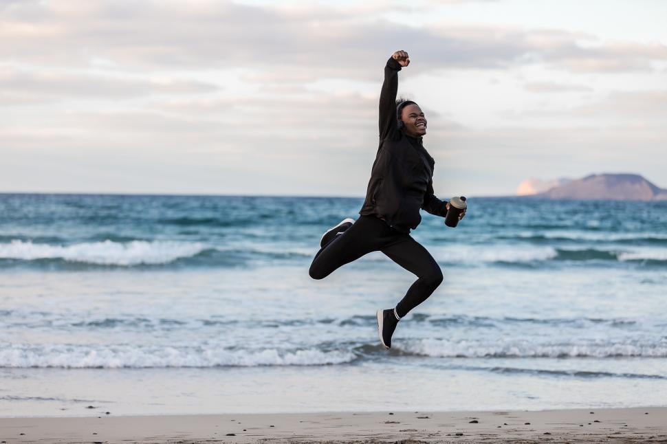 Free Image of Cheerful black athlete jumping near sea 
