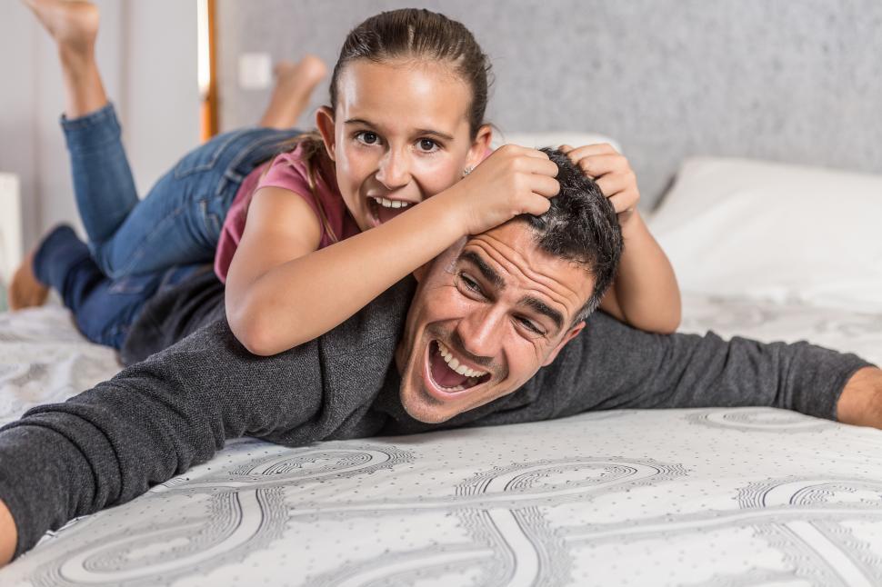 Download Free Stock Photo of father playing with his daughter on bed 