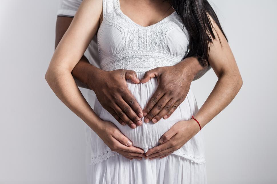 Download Free Stock Photo of Crop of black man making heart sign on pregnant belly 
