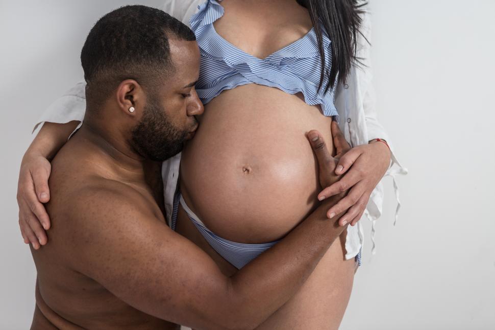 Free Image of Man hugging and kissing pregnant stomach 