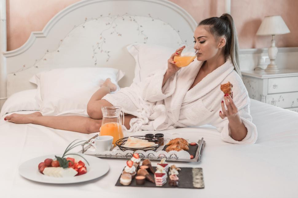 Free Image of Sensual woman drinking juice on bed 