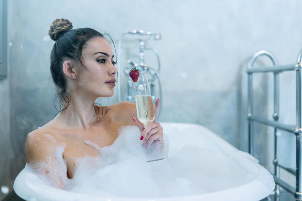 Download Free Stock Photo of Dreamy female with champagne taking bath 